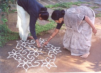 Mother teaches Rangoli to daughter